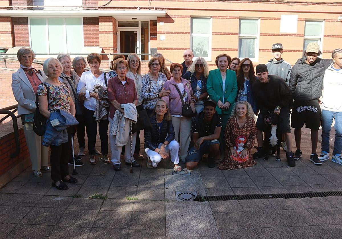 Integrantes de la asociación vecinal El Fumeru y jóvenes del barrio posan delante del local de la entidad en la calle Río de Oro.