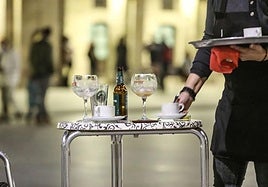 Un camarero atiende una terraza.