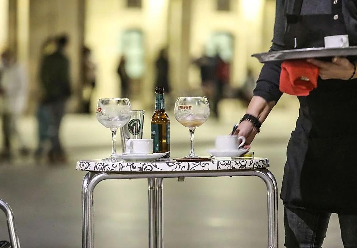 Un camarero atiende una terraza.