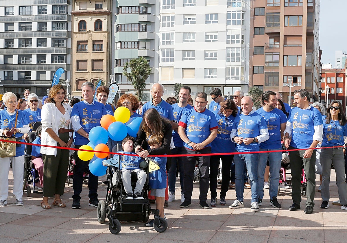 Los hermanos Mateo y Bruno, ayudados por su madre, Jennifer Poncelas, cortan la cinta para dar inicio a la marcha inclusiva por el Muro de San Lorenzo.