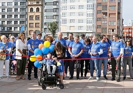 Los hermanos Mateo y Bruno, ayudados por su madre, Jennifer Poncelas, cortan la cinta para dar inicio a la marcha inclusiva por el Muro de San Lorenzo.