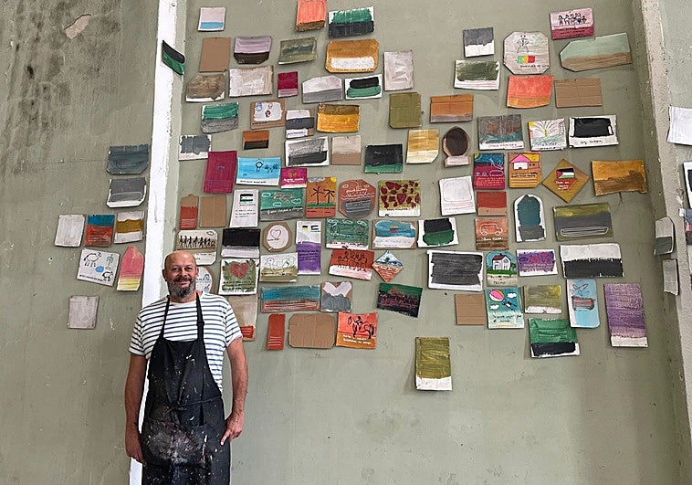 Toño Velasco junto a los cartones pintados por los migrantes en la Fábrica de Armas.