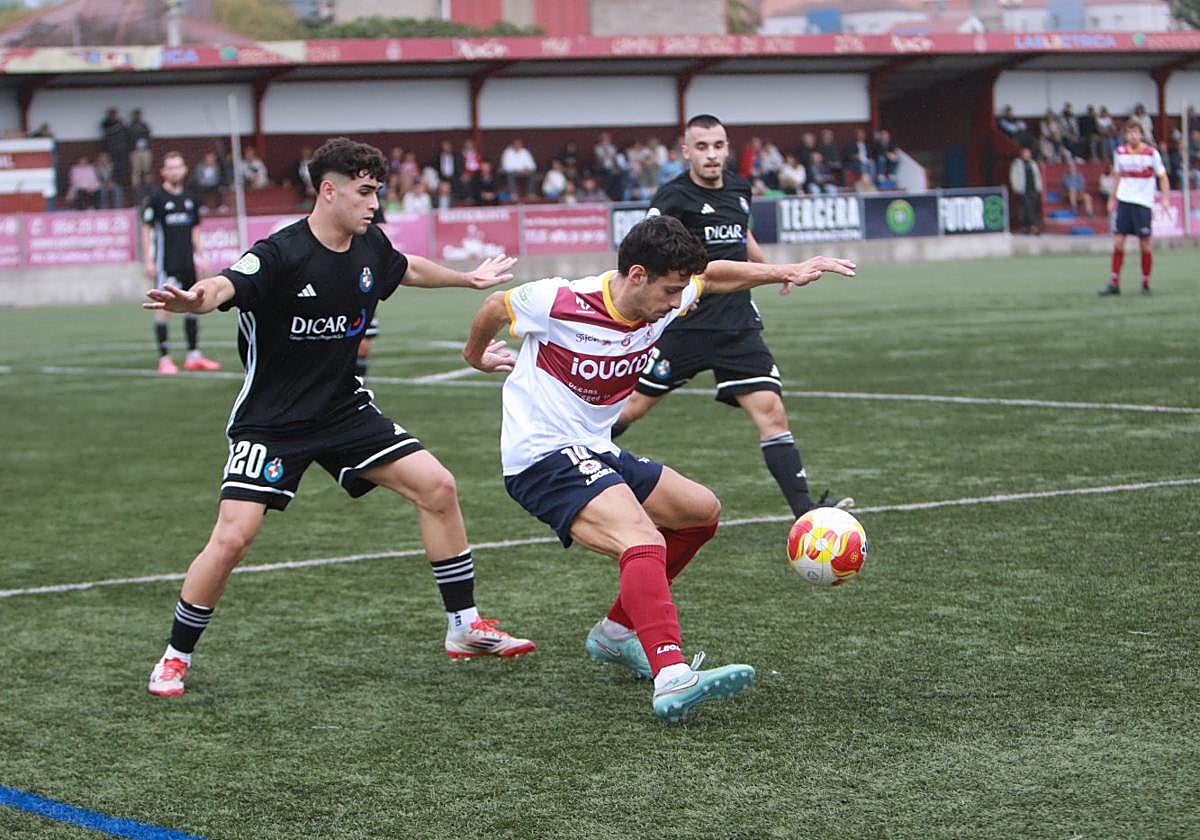 Borja Prieto trata de dar un pase ante la oposición de Álex Solís.