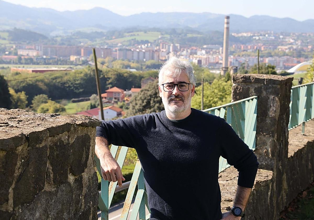 Alberto Velasco, el presidente de la Asociación de Vecinos de Valliniello, en la sede de la asociación con una vista de Avilés.