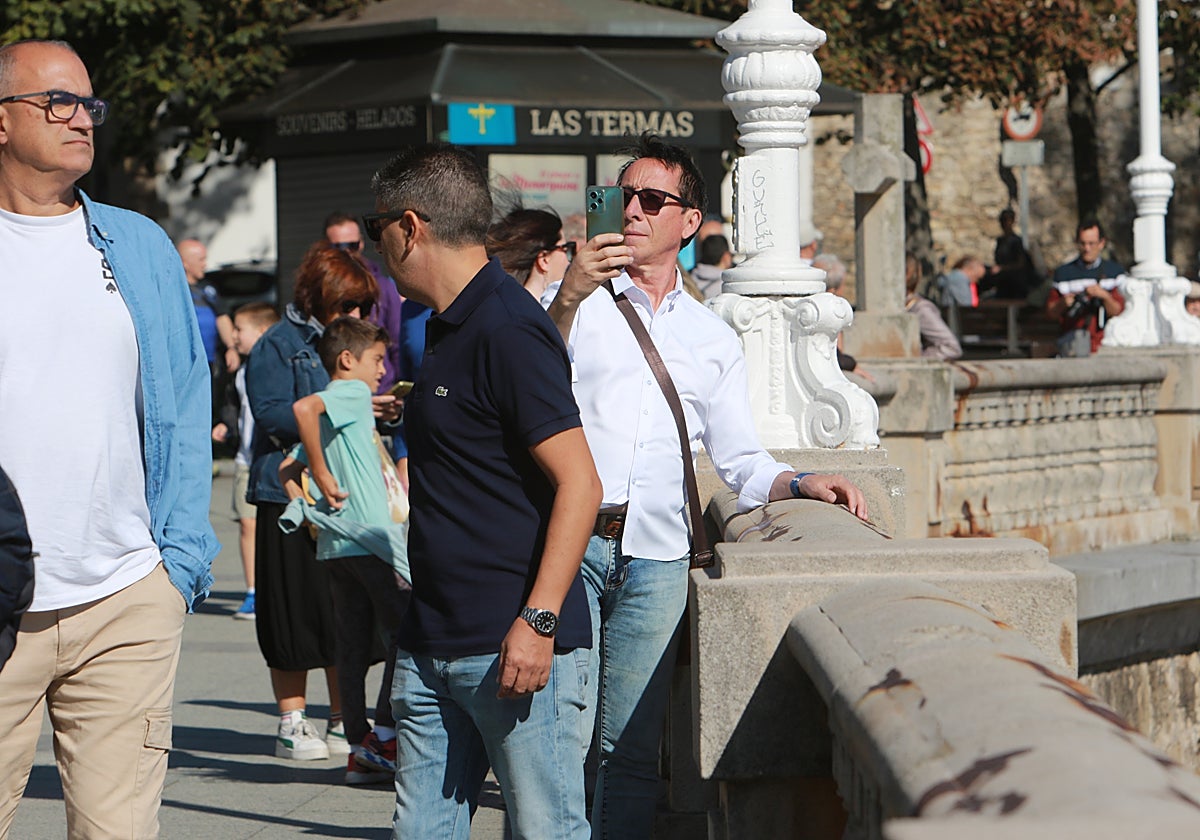Un turista hace una foto desde el gijonés Muro de San Lorenzo, con el Campo Valdés a su espalda.