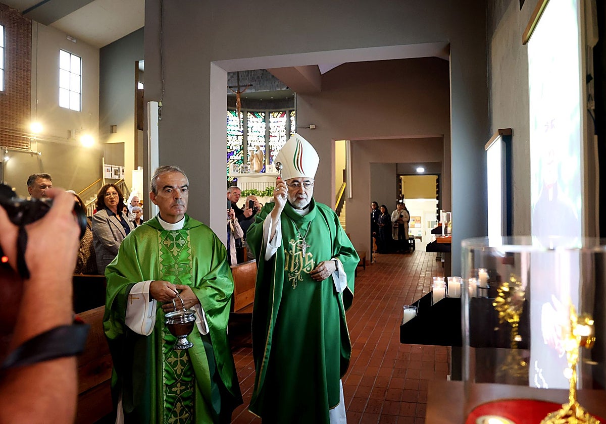 Jesús Sanz Montes, hisopo en mano, bendice la capilla de Carlo Acutis en presencia de Jaime Sanz.