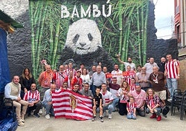 Integrantes de la Peña Ferrero, de Grado, durante la celebración, con la leyenda rojiblanca en el centro.