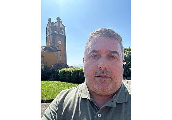 Celso Roces, con la iglesia de San Félix de Valdesoto al fondo.