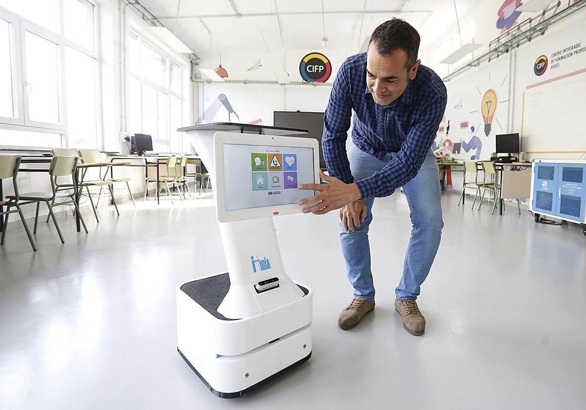 Roberto Pinillos, ingeniero de OffInnova, interactúa con el robot 'Higía', este viernes en el CIFP Avilés.