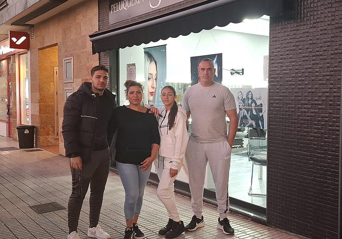Padres e hijos. Susana Torres, su marido, Julián Villaescusa, y sus dos hijos, Enrique y Ana María, frente a la peluquería de Villaviciosa.
