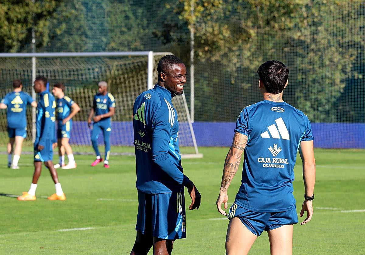 El defensa Bailly bromea con el centrocampista Colombatto en un entrenamiento del Real Oviedo.
