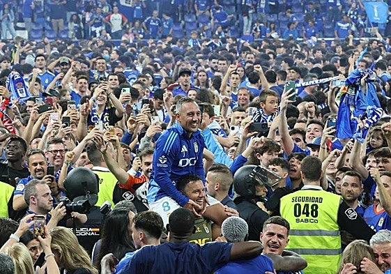 Cazorla, a hombros rodeado de la afición del Real Oviedo, que tomó el campo del Tartiere.