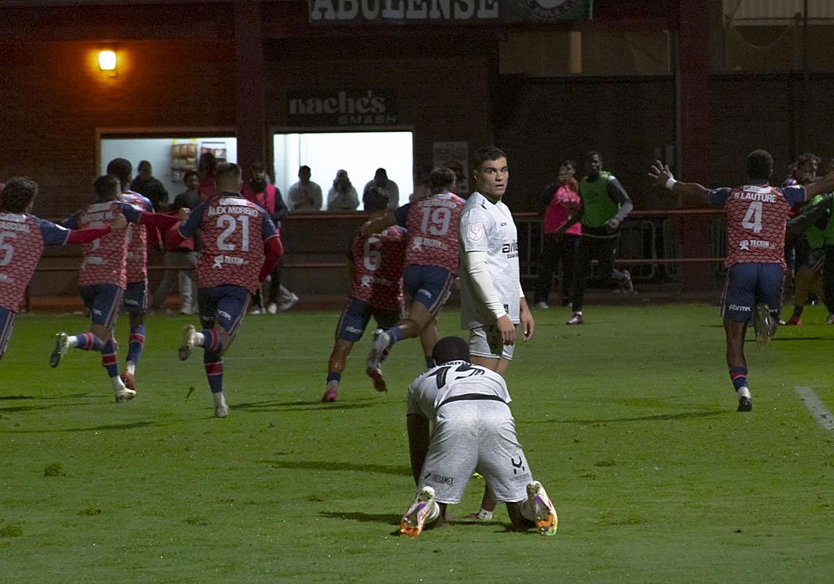 Los jugadores del Real Ávila celebran el gol de la victoria, con Eze arrodillado sobre el terreno de juego y Raúl Rubio mirando hacia atrás.