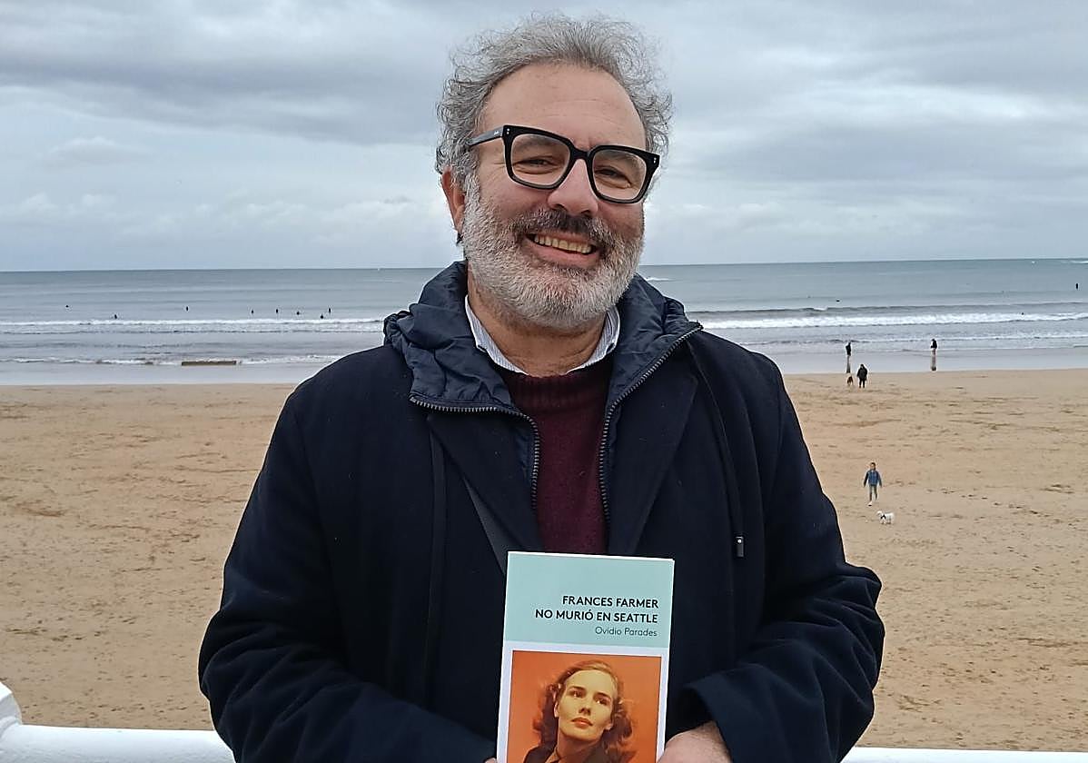 El escritor Ovidio Parades con su libro entre las manos en el Muro de Gijón.