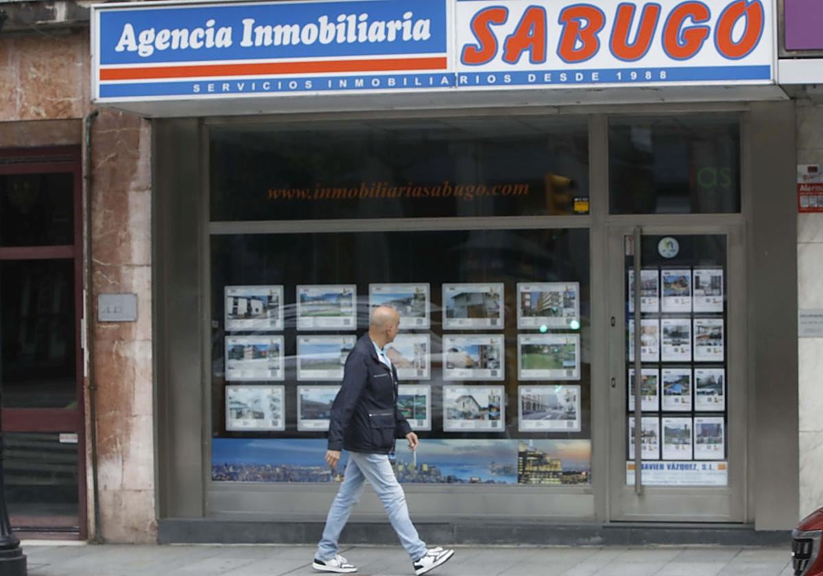 Un hombre observa la oferta de viviendas de una inmobiliaria en Gijón.