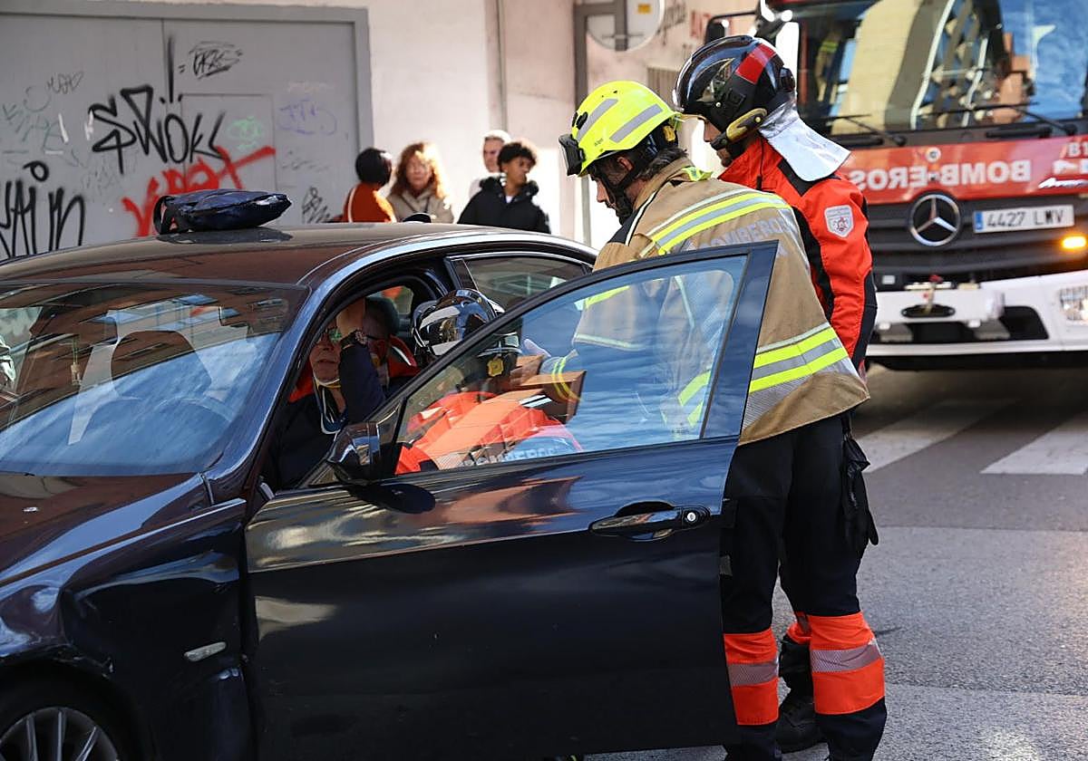 Los bomberos colocan un collarín al herido en el interior de su coche.