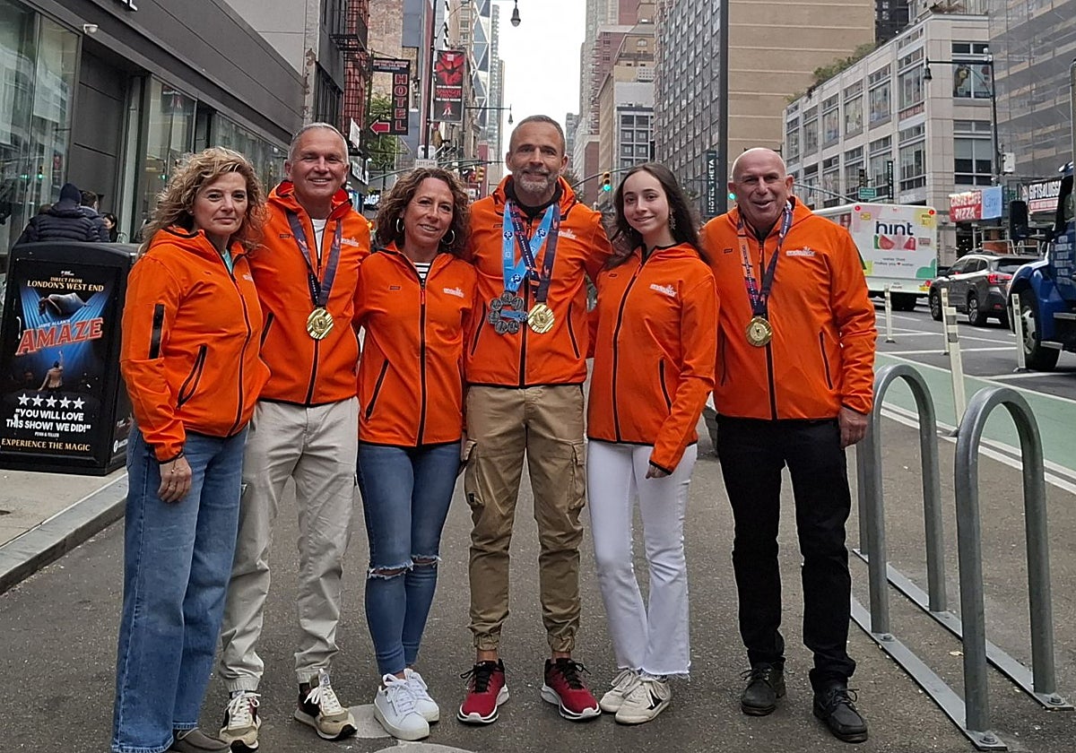 José Antonio Navarro, en el centro, con la medalla acreditativa de las seis 'majors', posa junto a Eduardo Sánchez y Jesús Iglesias, y a sus fieles animadoras.