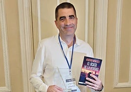 Alberto Meneses con la novela ganadora en sus manos.