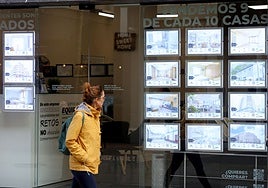 Una mujer observa los anuncios de una inmobiliaria.
