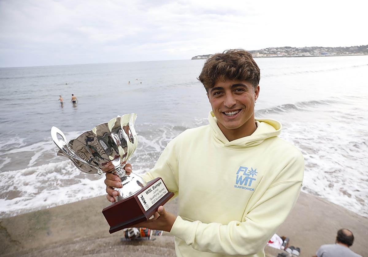 Alfonso Suárez posa con la copa de campeón europeo con el oleaje de San Lorenzo de fondo.