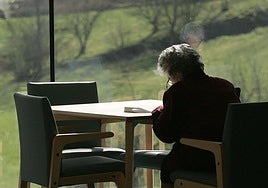 Una mujer lee en soledad en un centro sociosanitario.