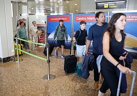 Pasajeros en la zona de llegadas del aeropuerto de Asturias.