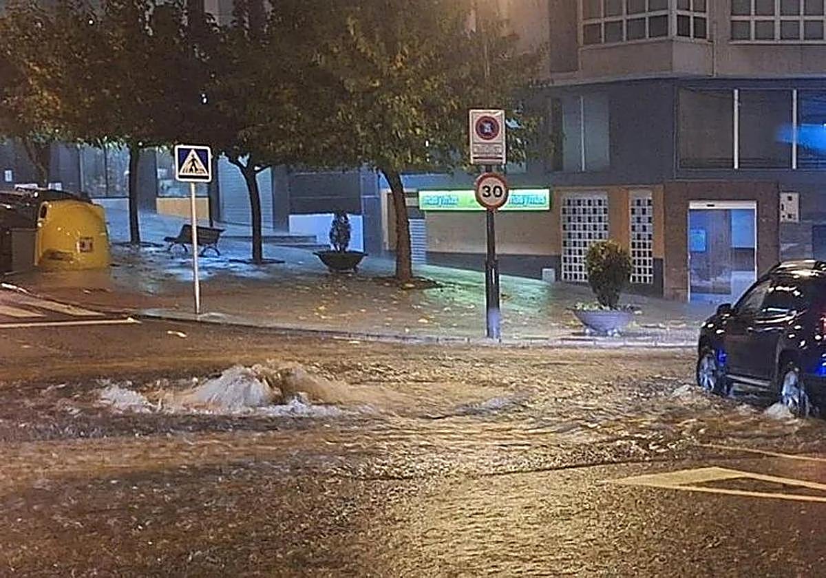 El agua brota de una alcantarilla tras las intensas lluvias que anegaron las calles de Avilés este domingo.