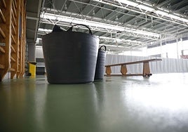 Cubos para recoger el agua de las goteras en un pabellón deportivo de Gijón.