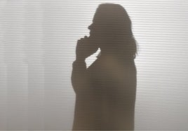 Una víctima de violencia machista habla por teléfono.
