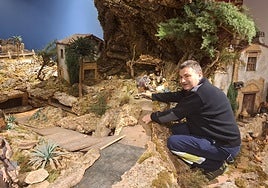 El belenista Nicolás Rodríguez coloca una de las piezas del nacimiento de La Oliva, en Villaviciosa.
