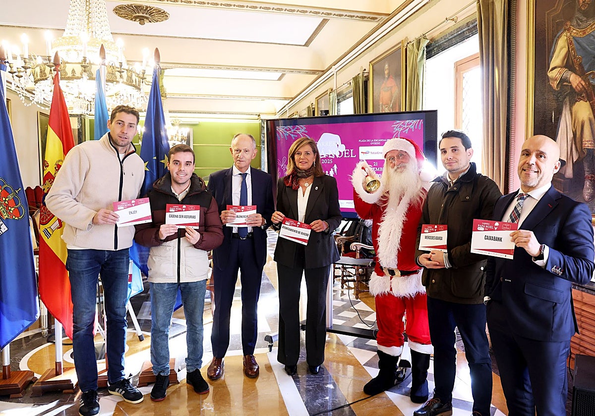 Presentación de la Carreara de Papá Noel by TotalEnergies, con Javier Sáenz de Jubera y Conchita Méndez, en el centro, junto a Papá Noel.
