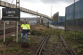 El jefe de la División de Operaciones Portuarias de Avilés, Juan Pantiga, junto al cartel que indica que el tren entra en zona del puerto en la margen izquierda.