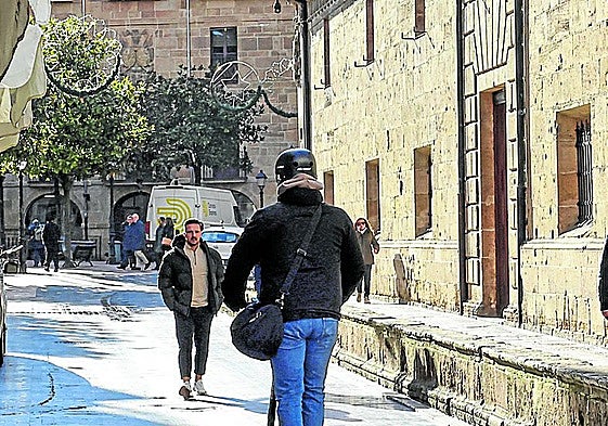 Un hombre se desplaza en patinete por El Antiguo.