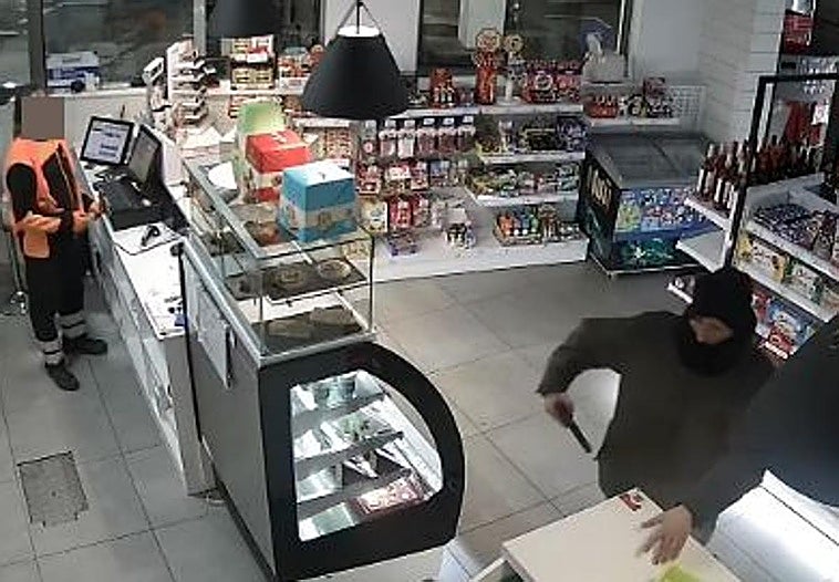 Momento en el que el atracador saca la pistola con la que amenazó a los trabajadores de la gasolinera de la avenida Portugal de Gijón.