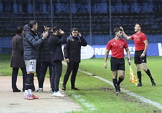 Los jugadores y el cuerpo técnico del Real Avilés protestan ante Francisco Crespo la decisión de conceder el gol de la victoria al Celta Fortuna el domingo en el Suárez Puerta.