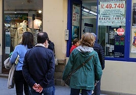 Varias personas hacen cola para comprar lotería en una administración