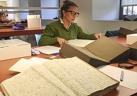 Dos de las voluntarias del Archivo Histórico Diocesano bucean en los libros parroquiales en busca de partidas que acrediten el origen de los emigrantes.