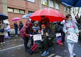 El pequeño Mael, sobre los hombros de su padre, y otros compañeros, este miércoles, antes de las clases, durante la protestas a puertas del Jacinto Benavente.