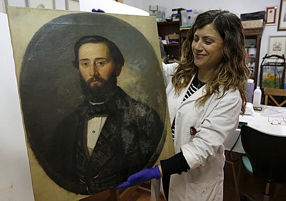 Laura Rodríguez sostiene una de las obras.