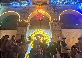 El alcalde de Villaviciosa, en el centro, brinda por la Navidad tras el encendido.