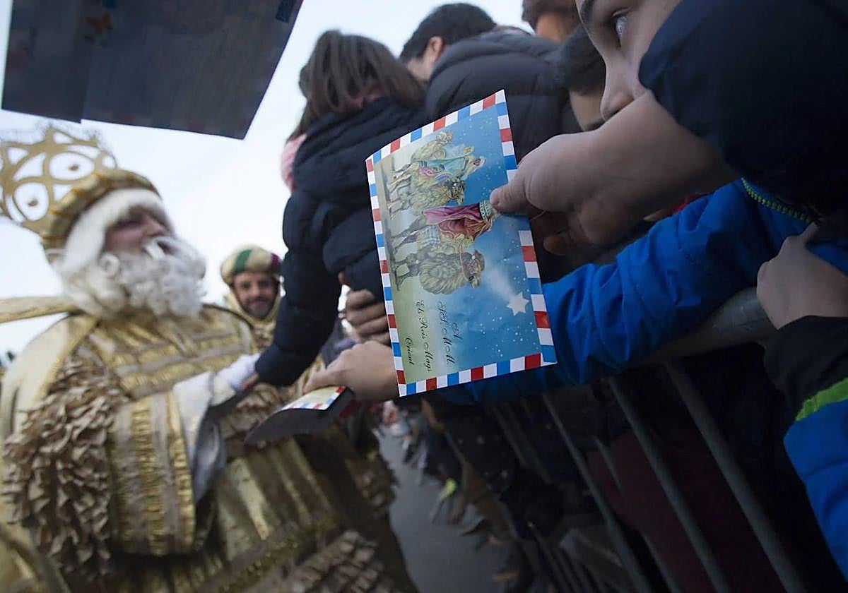 Un niño le da su carta al rey Melchor.