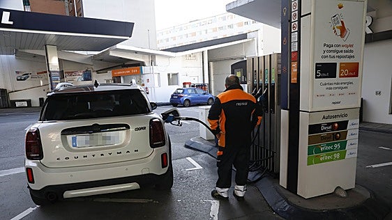 Un trabajador de una gasolinera de Gijón reposta el tanque de un turismo.