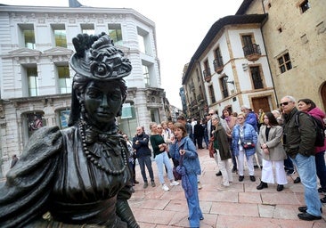 Una guía turística muestra a un grupo de visitantes la estatua de La Regenta, en Oviedo.
