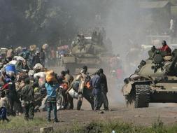 Carros de combate recorren las carreteras hacia Goma ante la expectación y el temor de miles de congoleños que huyen a su paso. /AP