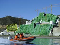 Ecologistas de Greenpeace cubren con una lona verde el hotel de veinte plantas de El Algarrobico, en Cabo de Gata./ Archivo