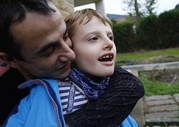 Eneko, junto a su padre en la imagen, pacede síndrome de Angelman. / José Montes