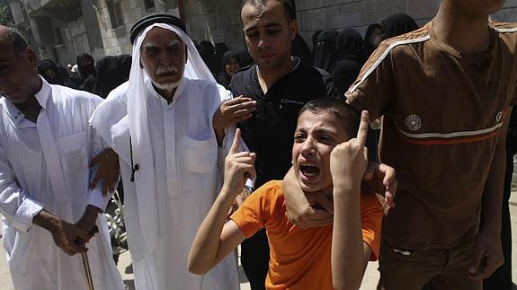 Un niño llora durante el entierro de un familiar.  Reuters