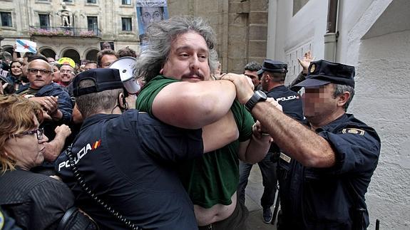 Varios manifestantes forcejean con agentes de la Policía.  