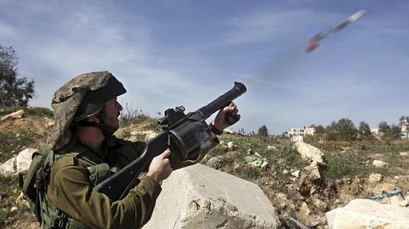 Un soldado israelí lanza gases lacrimógenos durante los enfrentamientos registrados con palestinos. 