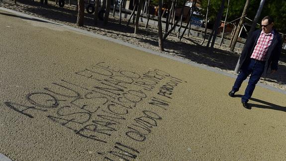 Una persona mira la pintada sobre la muerte de Francisco J. Romero. 